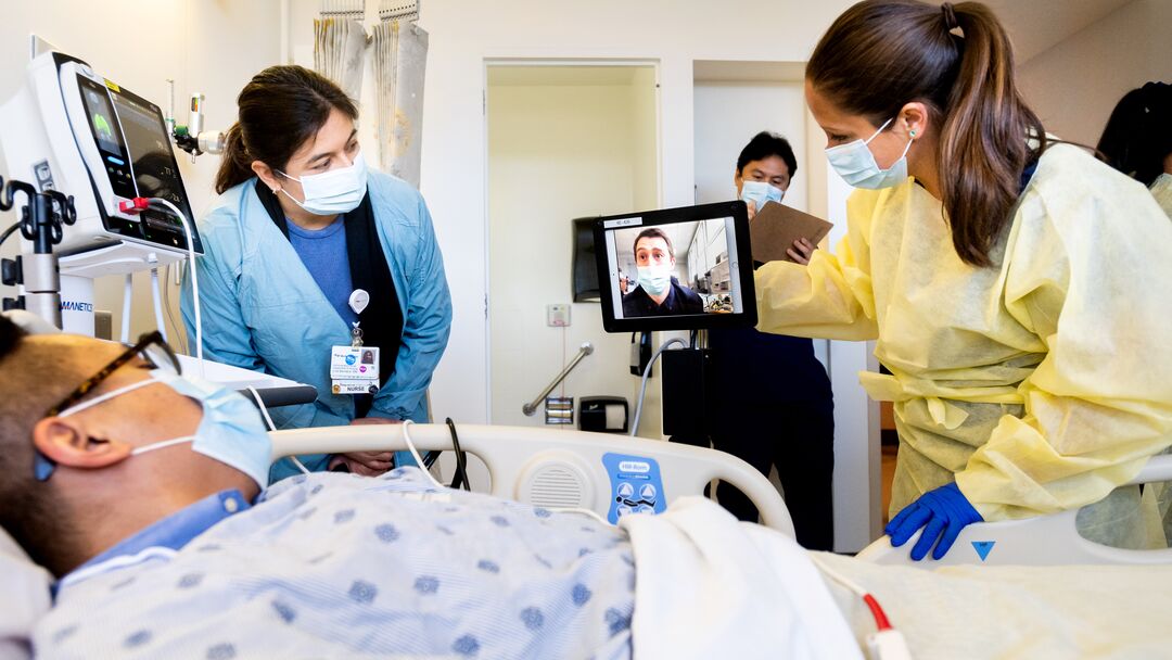 Healthcare professionals showing a patient a video on an iPad. 