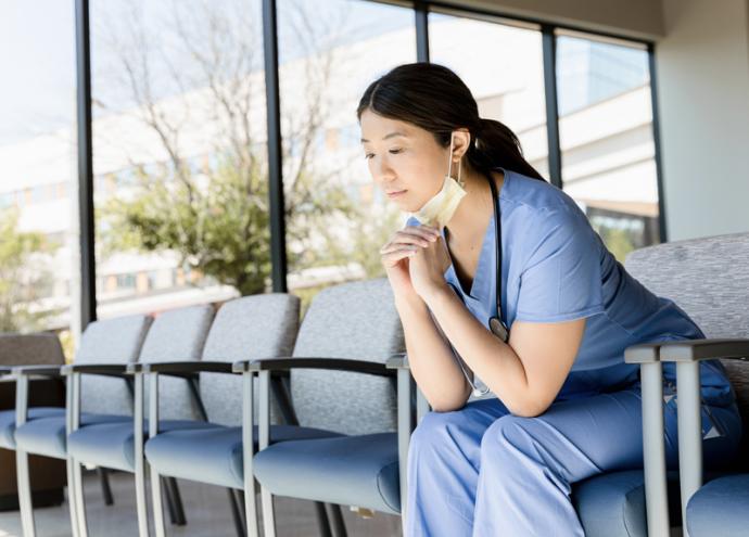 A nurse is sitting in a chair.